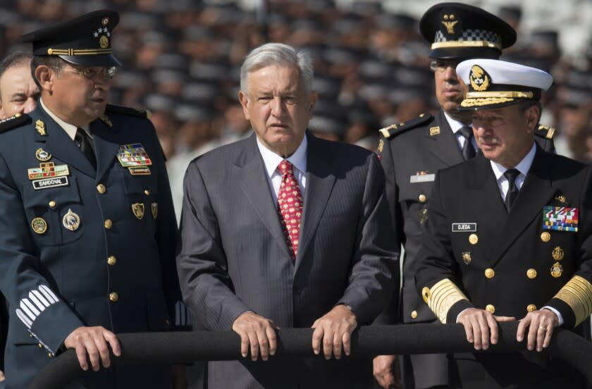 El presidente de México, Andrés Manuel López Obrador, flanqueado por el secretario de Defensa, general Luis Crescencio Sandoval, a la izquierda, y el secretario de Marina, José Rafael Ojeda, pasan revista a las tropas de la Guardia Nacional, en Ciudad de México, el 30 de junio de 2019. (Foto AP/Christian Palma, Archivo)