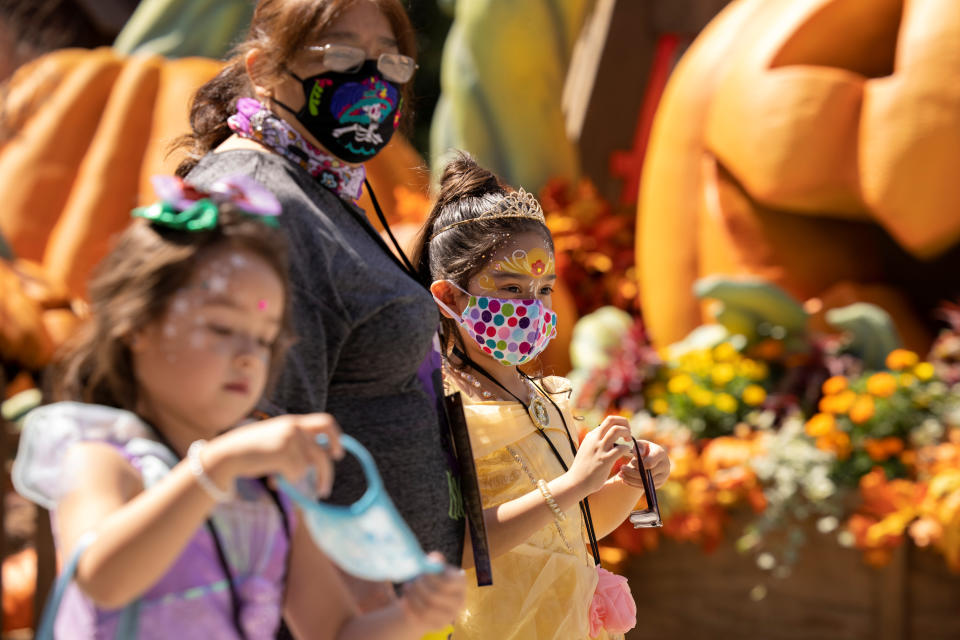 A family wears face masks as they attend Knott's Berry Farm's Halloween-themed attraction with social distancing during the outbreak of the coronavirus disease in Buena Park, California, U.S., September 25, 2020. REUTERS/Mike Blake