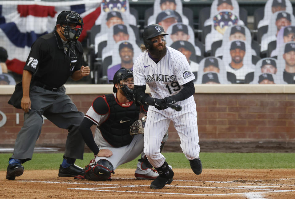 Colorado Rockies' Charlie Blackmon, front, follows the flight of his single as he breaks from the batter's box as Arizona Diamondbacks catcher Carson Kelly, back right, and home plate umpire Alfonso Marquez look on in the first inning of a baseball game Tuesday, Aug. 11, 2020, in Denver. (AP Photo/David Zalubowski)