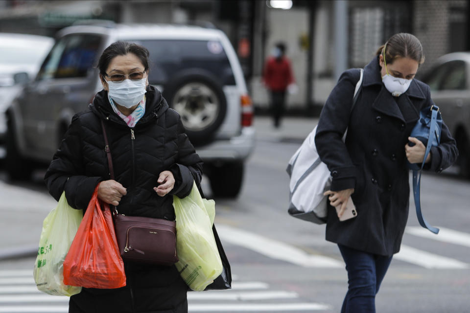 Pedestrians wearing protective masks cross Canal Street Tuesday, April 21, 2020, in New York. (AP Photo/Frank Franklin II)