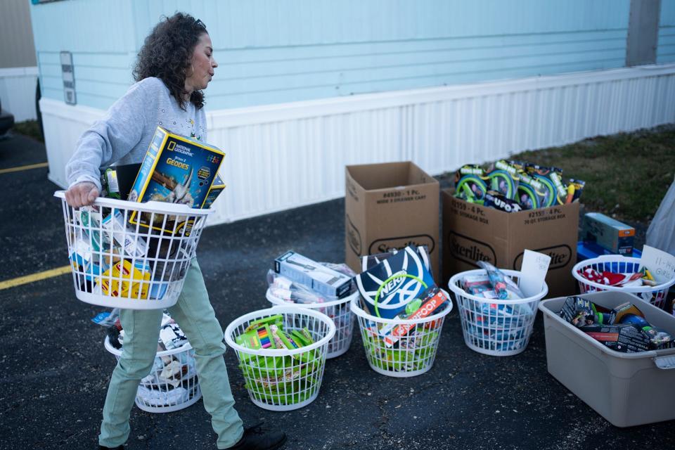 Sharon Bonazzo of Clintonville hauls out gifts, organized by gender and age, as she gets ready for a truck to pick them up.