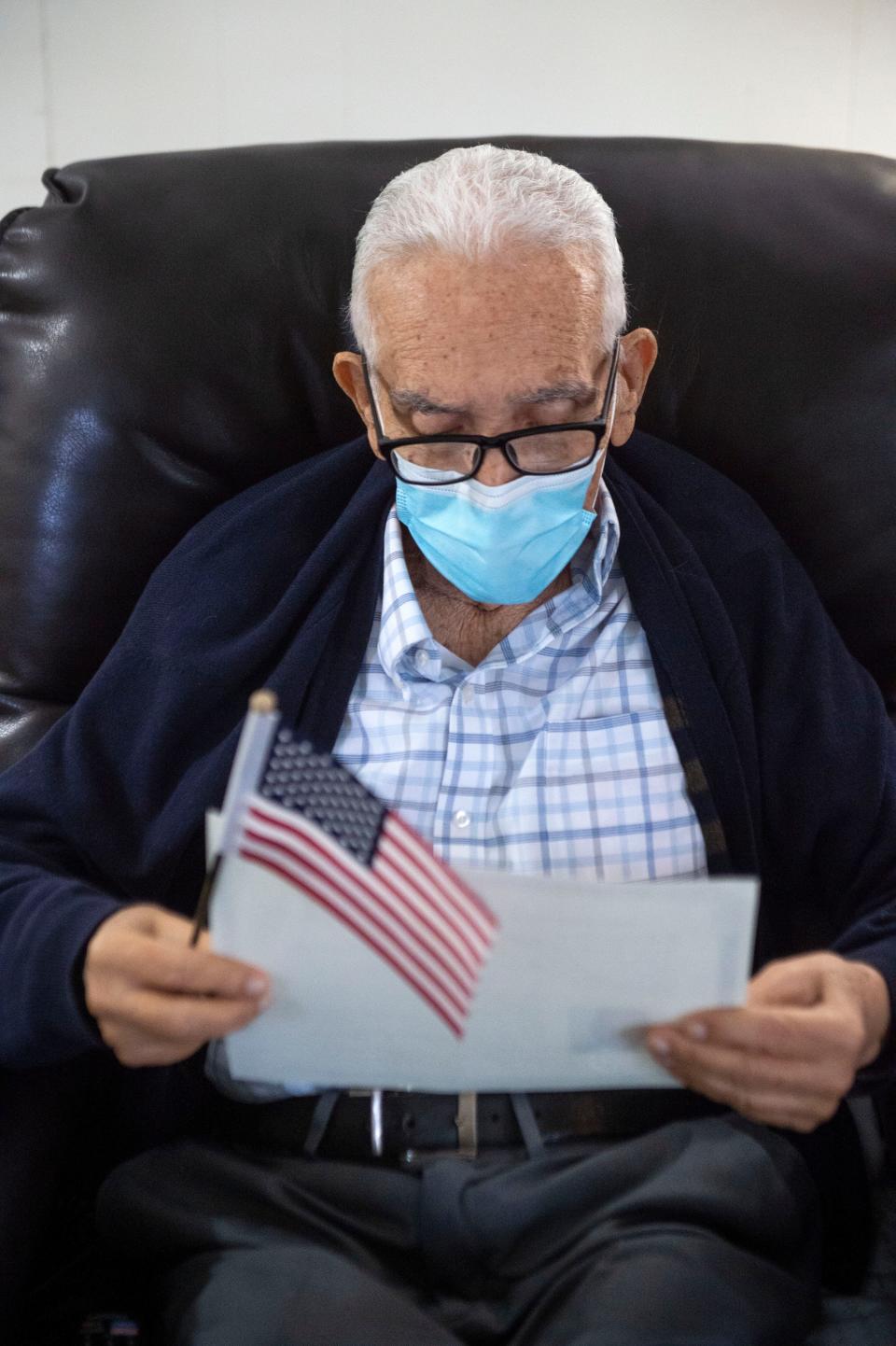 After passing his citizenship test several days prior and shortly after being sworn in as a U.S. citizen, Felix Taborda Romero reads over his Certificate of Naturalization on Monday at his home in Martin County, Florida.