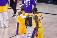 Los Angeles Lakers' Kentavious Caldwell-Pope, left, greets LeBron James, right, on the court during a time out from play in the second half an NBA conference final playoff basketball game against the Denver Nuggets on Friday, Sept. 18, 2020, in Lake Buena Vista, Fla. (AP Photo/Mark J. Terrill)