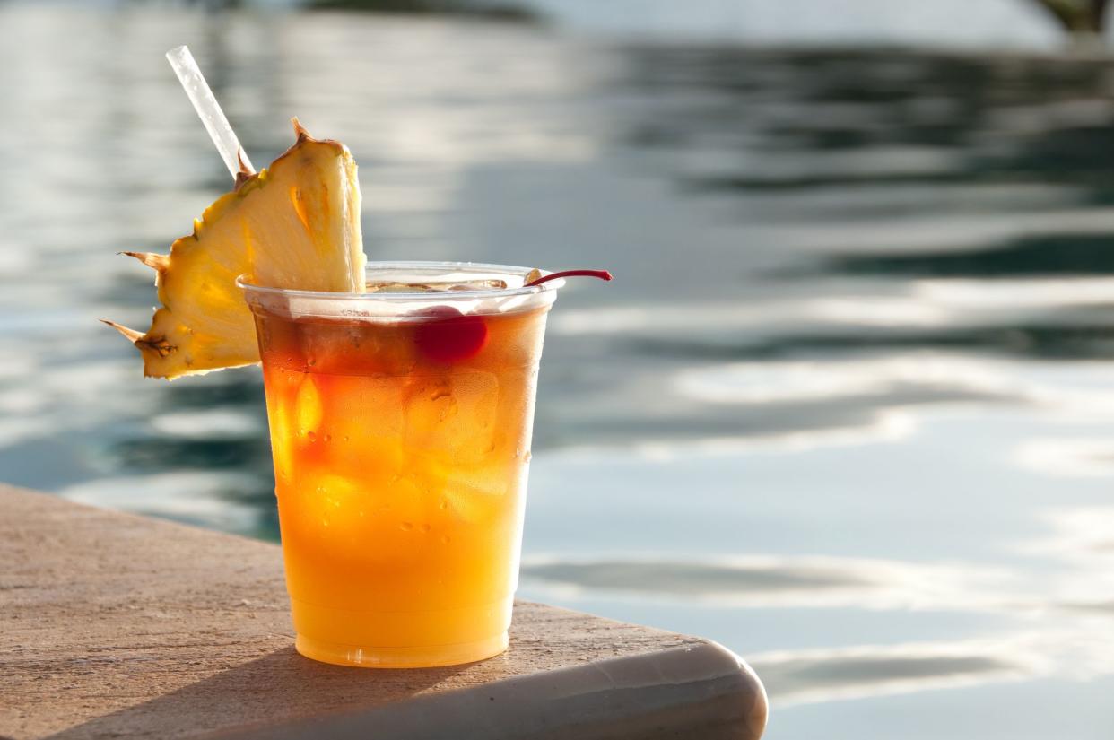 Mai Tai cocktail sitting on the edge of a swimming pool.