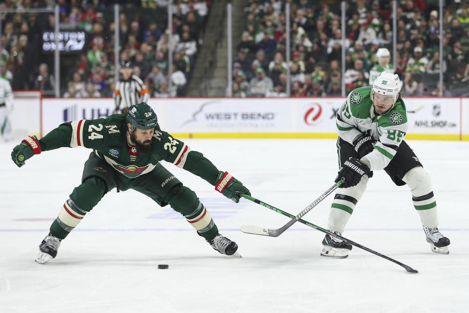 Dallas Stars center Matt Duchene, right, passes the puck as Minnesota Wild defenseman Zach Bogosian (24) defends during the first period of an NHL hockey game Monday, Jan. 8, 2024, in St. Paul, Minn. (AP Photo/Matt Krohn)