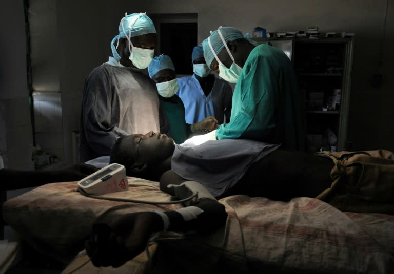 Doctor Evan Atar Adaha and his team perform nearly 60 surgeries per week in a room with just one light