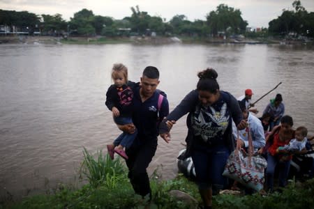 Central American migrants get off a raft after crossing the Suchiate river from Tecun Uman, in Guatemala, to Ciudad Hidalgo, as seen from Ciudad Hidalgo