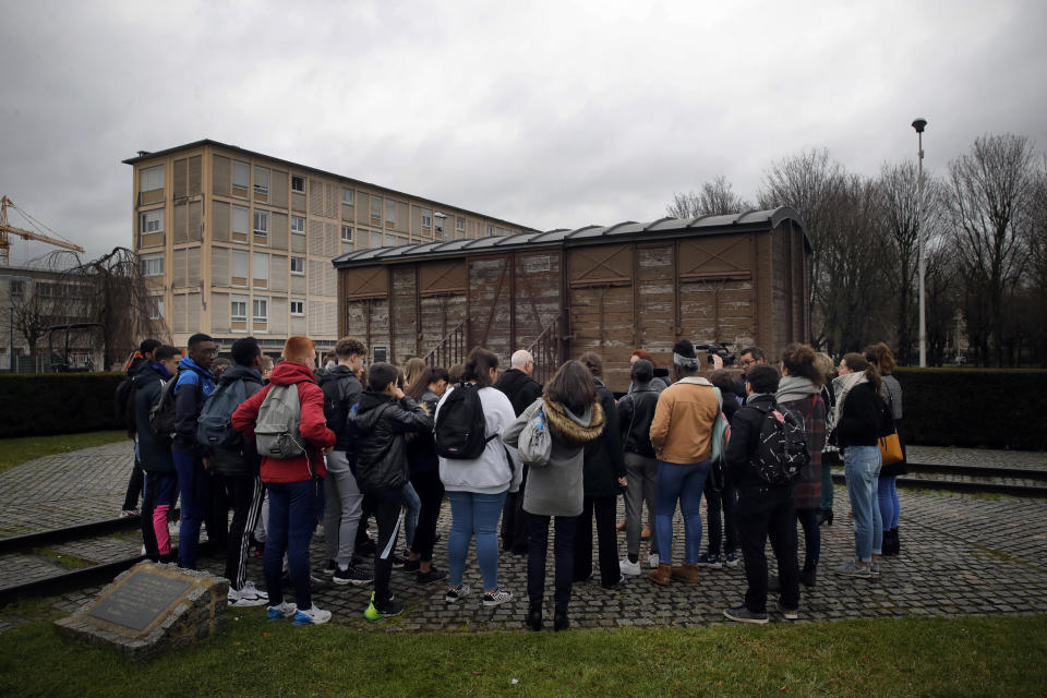 In this photo taken on Thursday Jan. 30, 2020, students listens to Victor Perahia, interned as a child in the Drancy camp and deported to Bergen-Belsen during a workshop dedicated to the Holocaust remembrance at the Drancy Shoah memorial, outside Paris. French Holocaust survivor Victor Perahia was 9 when his family was seized by the Nazis, but couldn't bear to speak about what happened for 40-years, but is now telling his story to schoolchildren at Drancy, backdropped by the buildings that once imprisoned him. (AP Photo/Christophe Ena)