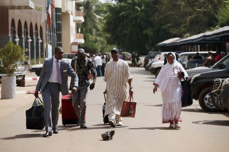 Rescued hostage celebrated Guinean singer Sékouba "Bambino" Diabate (with hat) leaves after picking up his belongings at the Radisson hotel in Bamako, Mali, November 21, 2015 following an attack by Islamist militants. REUTERS/Joe Penney