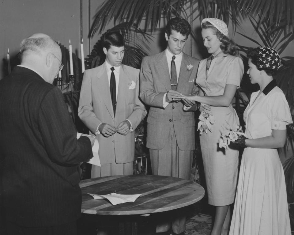 <p>Janet Leigh and Tony Curtis decided on an intimate affair at home in Greenwich, Connecticut. For the ceremony, Janet wore a mid-length, short-sleeved suit, a patterned scarf, and a white embroidered juliet cap. </p>