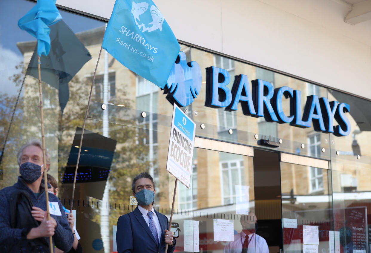 Banners held up by protesters outside Barclays bank in Broadmead, Bristol, to protest against what they have termed the financing of climate devastation by the bank. Extinction Rebellion and Stop Ecocide created a mock crime scene outside the branch as part of the protest.