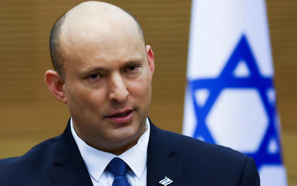 Naftali Bennett in front of the Israeli flag - REUTERS/Ronen Zvulun