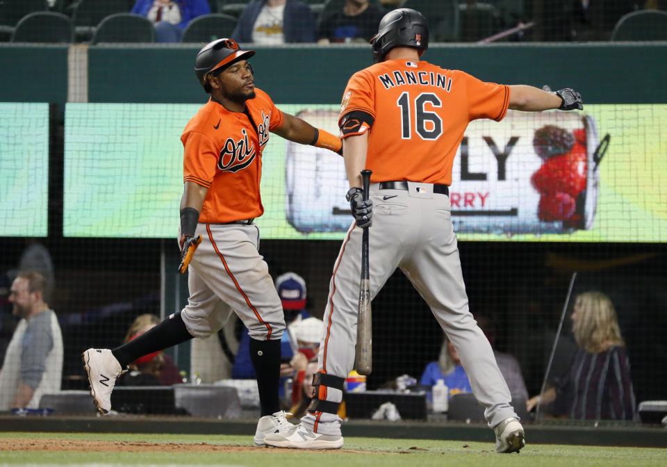 Baltimore Orioles' Maikel Franco, left, slaps hands with Trey Mancini after hitting a two-run home run against the Texas Rangers during the ninth inning of a baseball game in Arlington, Texas, Saturday, April 17, 2021. (AP Photo/Ray Carlin)