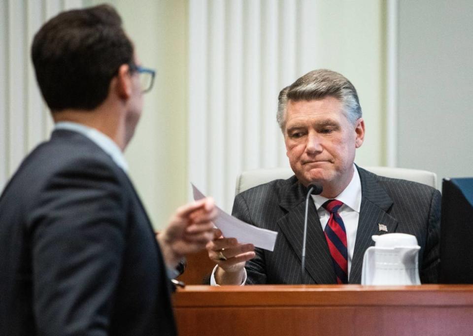 Josh Lawson, chief counsel for the state Board of Elections and Ethics Enforcement, left, hands Mark Harris, Republican candidate in North Carolina’s 9th Congressional race, a document during the fourth day of a public evidentiary hearing on the 9th Congressional District voting irregularities investigation Thursday, Feb. 21, 2019, at the North Carolina State Bar in Raleigh.