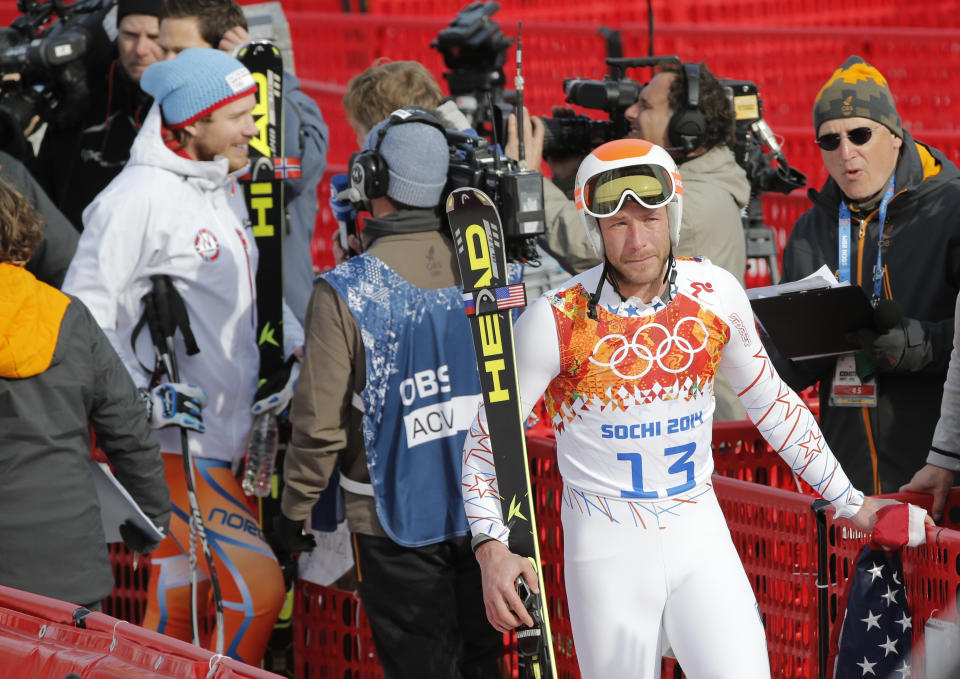 Gold medal winner Norway's Kjetil Jansrud, left, is interviewed in the finish area as joint bronze medal winner United States' Bode Miller walks away in tears after his television interview at the Sochi 2014 Winter Olympics, Sunday, Feb. 16, 2014, in Krasnaya Polyana, Russia. (AP Photo/Christophe Ena)