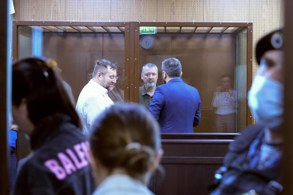 Igor Girkin, centre, also know as Igor Strelkov, the former military chief for Russia-backed separatists in eastern Ukraine speaks with his lawyer standing in a glass cage in a courtroom at the Moscow's Meshchansky District Court in Moscow, Russia, Friday, July 21, 2023. A prominent Russian hard-line nationalist who accused President Vladimir Putin of weakness and indecision in Ukraine was detained Friday on charges of extremism, a signal the Kremlin has toughened its approach with hawkish critics after last month's abortive rebellion by the Wagner mercenary company. (AP Photo/Alexander Zemlianichenko)