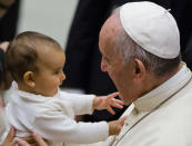 <p>Dieses kleine Mädchen fühlt sich bei seinem Besuch im Vatikan auf dem Arm von Papst Franziskus sichtlich wohl. (Bild: AP Photo/Domenico Stinellis) </p>