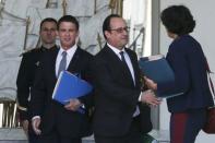 French President Francois Hollande (C) stands between Prime Minister Manuel Valls (L) and Labour Minister Myriam El Khomri (R) after the weekly cabinet meeting at the Elysee Palace in Paris, France, May 25, 2016. REUTERS/Pascal Rossignol