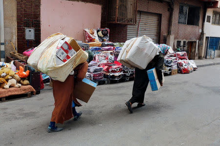 Moroccans women carry goods after crossing the border from Spain's North African enclave of Melilla into Moroccan settlement of Beni Ansar, in Beni Ansar, Morocco July 18, 2017. Picture taken July 18, 2017. REUTERS/Youssef Boudlal