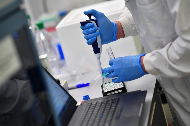 Scientists work at a laboratory where they sequence the novel coronavirus genomes in Cambridge