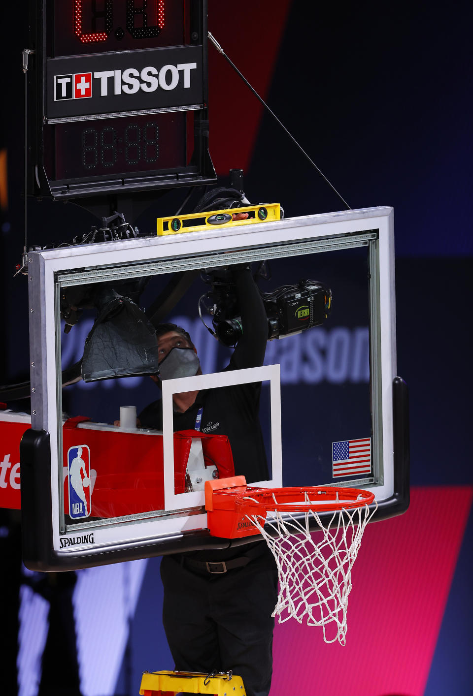 A leveler is brought to the court as players complained that the rim was crooked in the first half of Game 1 of an NBA basketball first-round playoff series, Tuesday, Aug. 18, 2020, in Lake Buena Vista, Fla. (Mike Ehrmann/Pool Photo via AP)