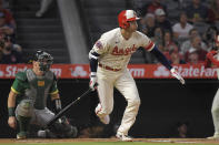 Los Angeles Angels' Shohei Ohtani, right, runs to first as he hits as RBI single while Oakland Athletics catcher Sean Murphy kneels at the plate during the first inning of a baseball game Thursday, Sept. 29, 2022, in Anaheim, Calif. (AP Photo/Mark J. Terrill)