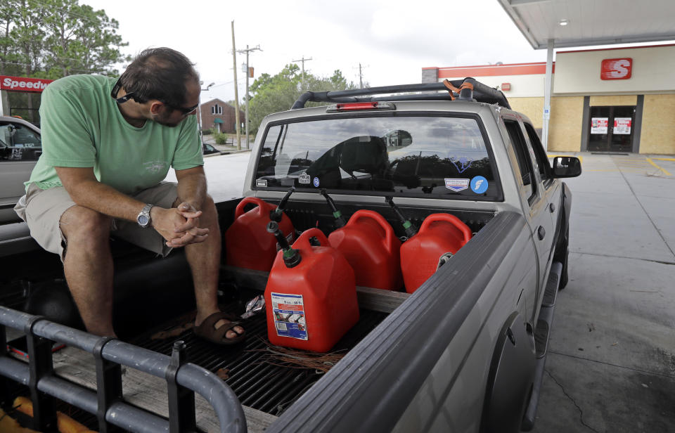 FILE - In this Sept. 17, 2018, file photo Nick Monroe waits at a gas station in hopes a truck will bring fuel for his vehicles and generator near Wilmington, N.C., in preparation for Hurricane Florence. Backup power options range from gasoline-powered portable generators, which can cost $1,000 or more, to solar panels plus batteries, which cost tens of thousands of dollars to purchase and install. (AP Photo/Chuck Burton, File)