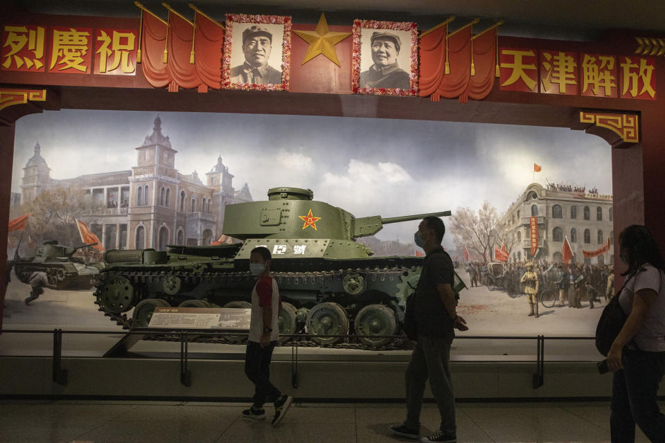 Visitors walk past a tank confiscated from a Japanese tank factory in China after the War of Resistance against Japanese Aggression in Beijing on Thursday, Sept. 3, 2020. China on Thursday commemorated the 75th anniversary of the end of World War II in the Pacific, during which it endured a brutal invasion and occupation of much of its territory by Japan. (AP Photo/Ng Han Guan)