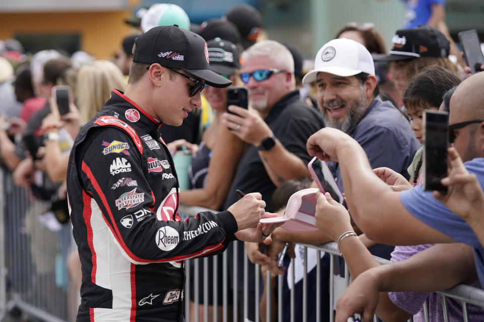 Christopher Bell signs autographs before the NASCAR Cup Series auto race at Homestead-Miami Speedway, Sunday, Oct. 22, 2023 in Homestead, Fla. Bell won the race. (AP Photo/Wilfredo Lee ).