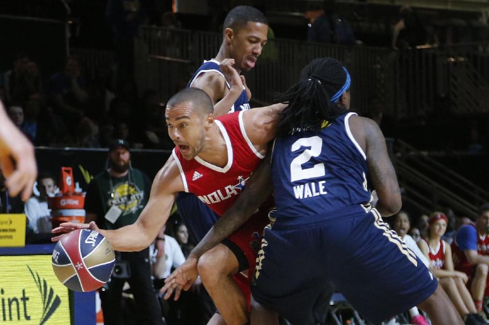 East's Wale (2) blocks West's Jesse Williams as Nick Cannon helps defend during the second half of the NBA All-Star celebrity basketball game in New Orleans, Friday, Feb. 14, 2014. The East won 60-56. (AP Photo/Bill Haber)