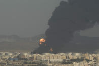 A cloud of smoke rises from a burning oil depot in Jiddah, Saudi Arabia, Friday, March 25, 2022. (AP Photo/Hassan Ammar)