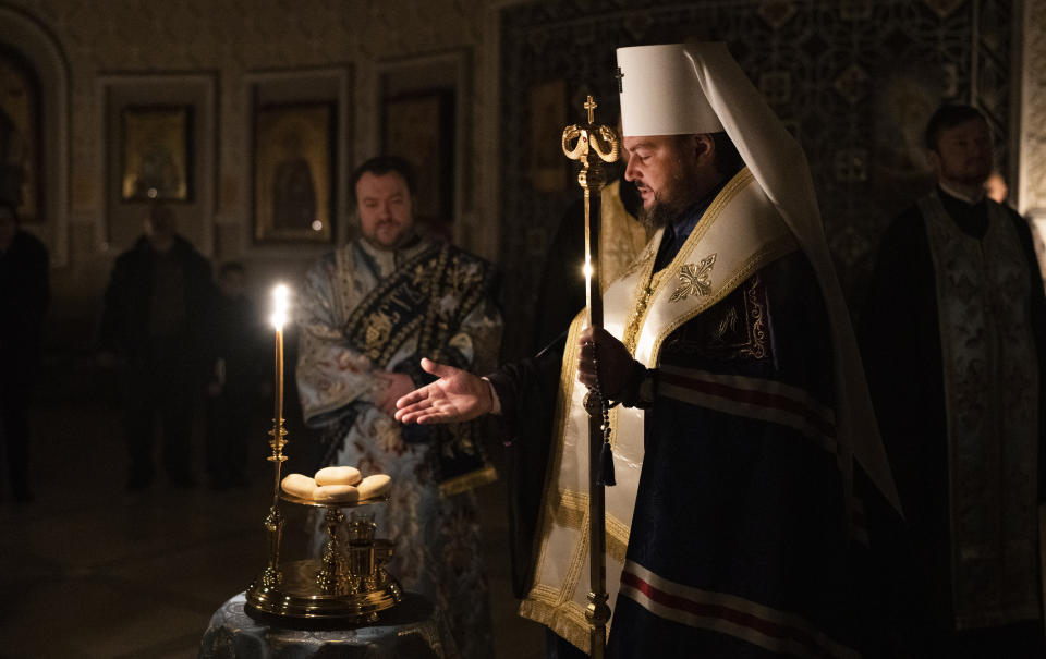 Metropolitan Oleksandr delivers a religious service with clerics inside the Transfiguration of Jesus Orthodox Cathedral during blackout caused by recent Russian rocket attacks, in Kyiv, Ukraine, Saturday, Dec. 3, 2022. A top Orthodox priest in Ukraine's capital says he supports the efforts of President Volodymyr Zelenskyy's government and counter-intelligence agency to end Russian spying and meddling in Ukrainian politics through a Moscow-affiliated church. (AP Photo/Efrem Lukatsky)