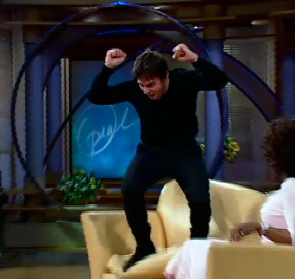 Oprah Winfrey watches as her guest, actor Tom Cruise, hops onto a couch.