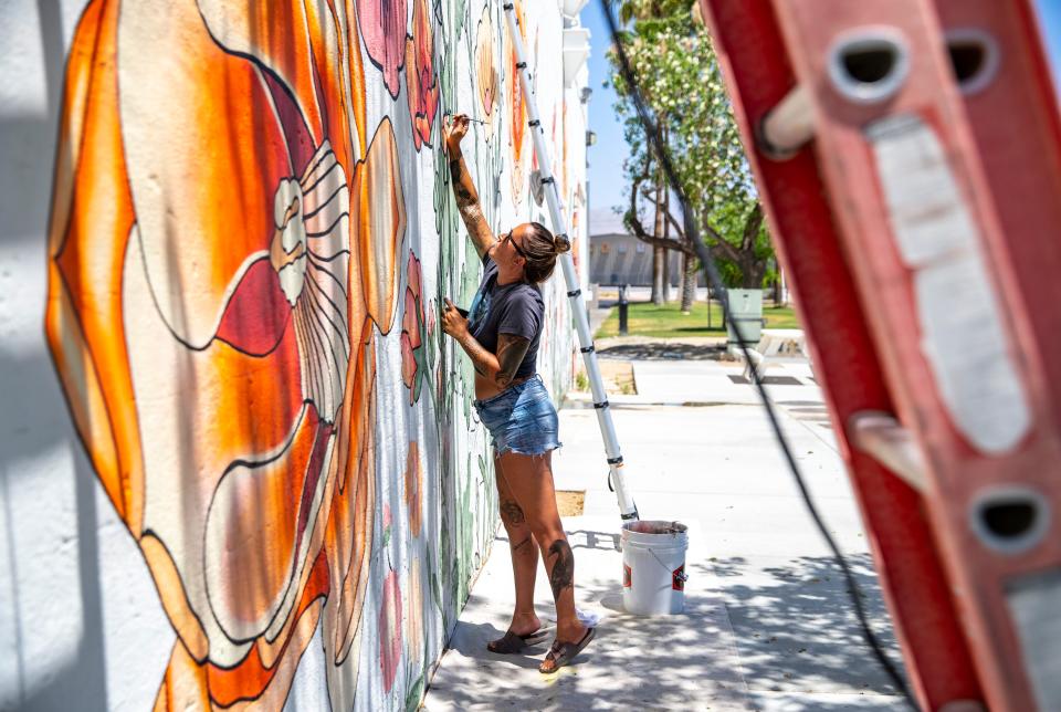 Randi Wilson, a Morongo Valley tattoo artist and mural painter, works on her latest mural along Miles Avenue in Indio on May 30, 2024.