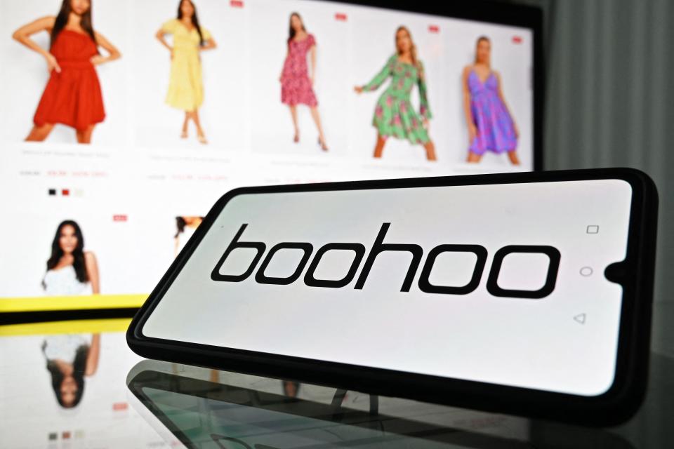 An illustration with a mobile phone and laptop shows the logo and website of online fashion group Boohoo on August 12, 2021. (Photo by JUSTIN TALLIS / AFP) (Photo by JUSTIN TALLIS/AFP via Getty Images)