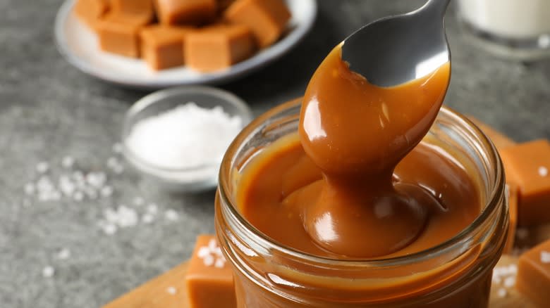 caramel sauce in a jar with a spoon