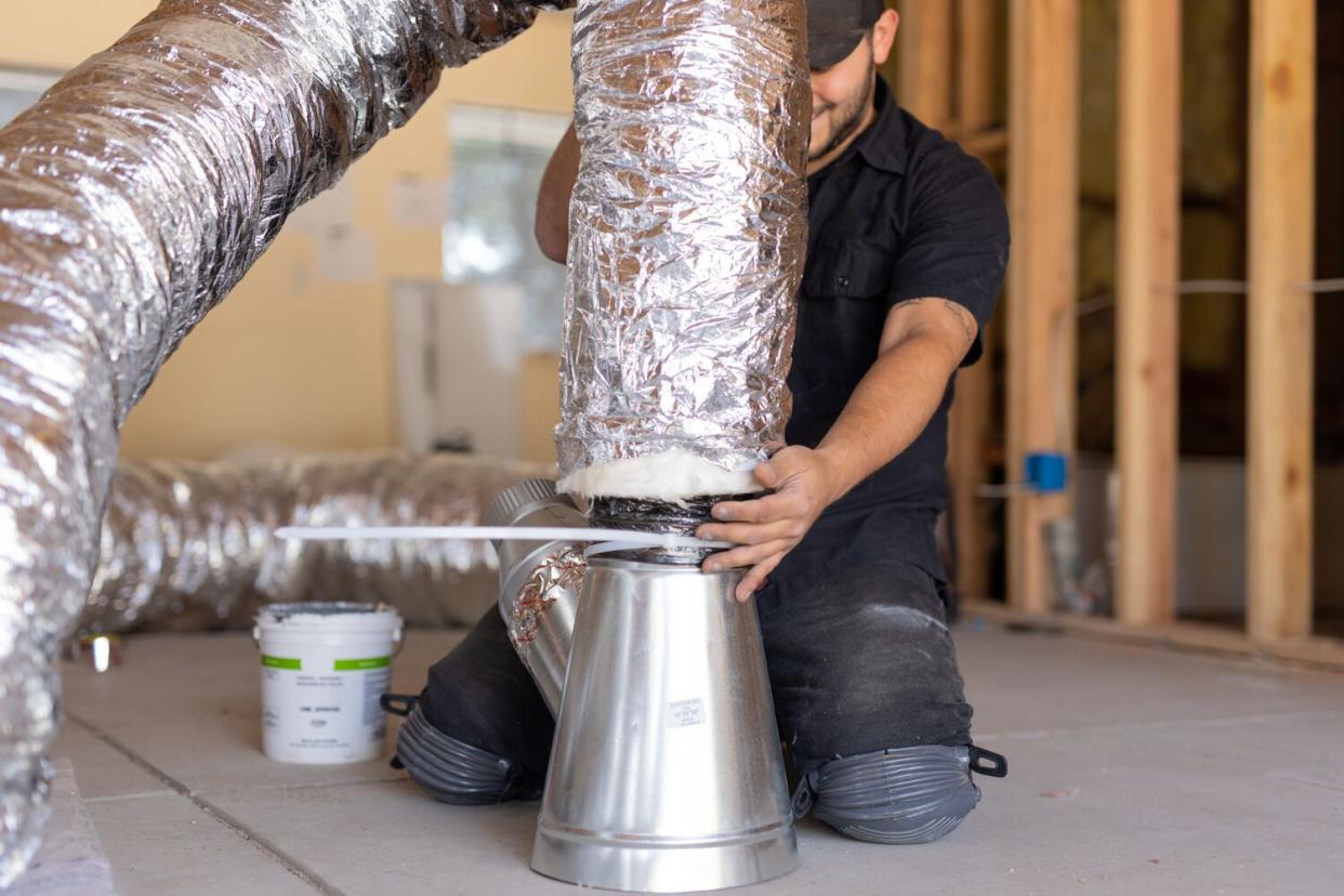 man working on HVAC duct system