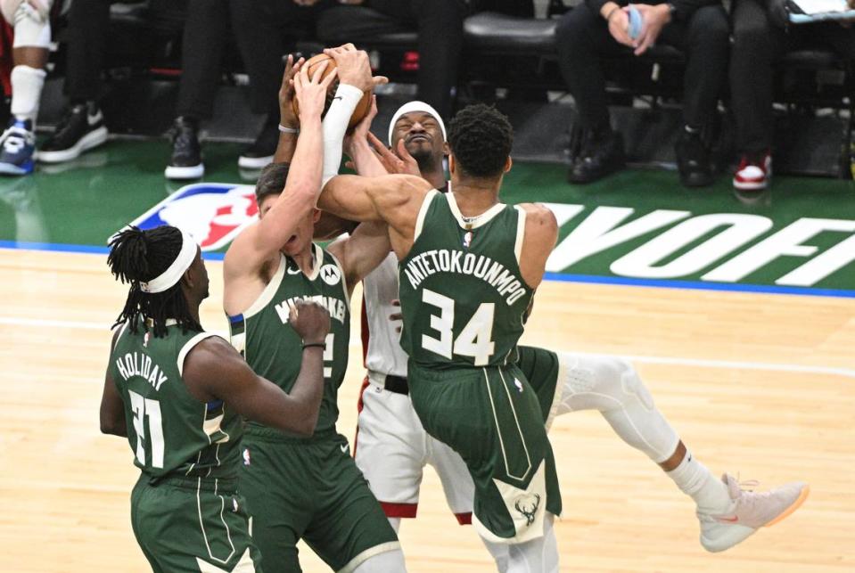 El jugador del Heat Jimmy Butler (centro) lucha por una pelota con Giannis Antetokounmpo, de los Bucks, en el quinto partido de la serie de playoffs de la NBA, celebrado el 26 de abril de 2023 en Milwaukee.