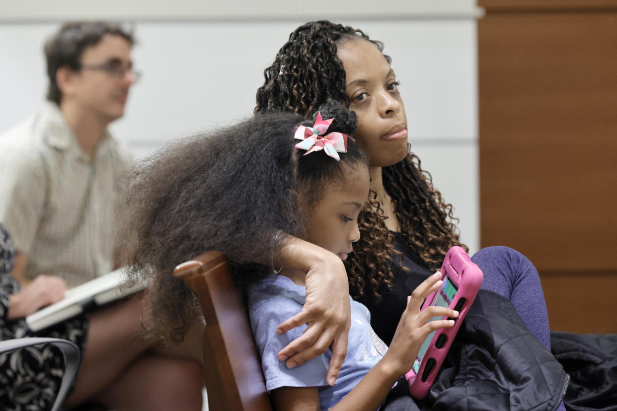 Philana Holmes and her daughter Olivia Caraballo, 7 listen to the final witness in their case at the Broward County Courthouse in Fort Lauderdale on Wednesday May 10, 2023. (Mike Stocker/South Florida Sun-Sentinel via AP)