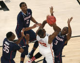 Iowa State's Dustin Hogue goes up for a shot as Connecticut's Amida Brimah, left, DeAndre Daniels, center, and Terrence Samuel defend during the first half in a regional semifinal of the NCAA men's college basketball tournament Friday, March 28, 2014, in New York. (AP Photo/Julio Cortez)