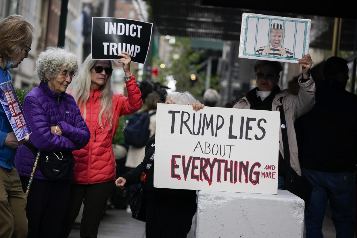 Protesters hold signs outside Trump Tower as the former President Donald Trump is deposed in New York, Monday, Oct. 18, 2021. Trump is in New York City to provide a videotaped deposition in a case about his security team's crackdown on a protest during the early days of his presidential campaign in 2015. (AP Photo/Seth Wenig)