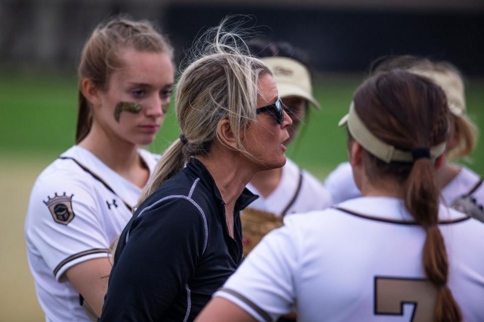 Ava Zachary (left) watches as Penn coach Beth Zachary talks with her team between innings during the Penn vs. Northridge softball game Tuesday, April 12, 2022