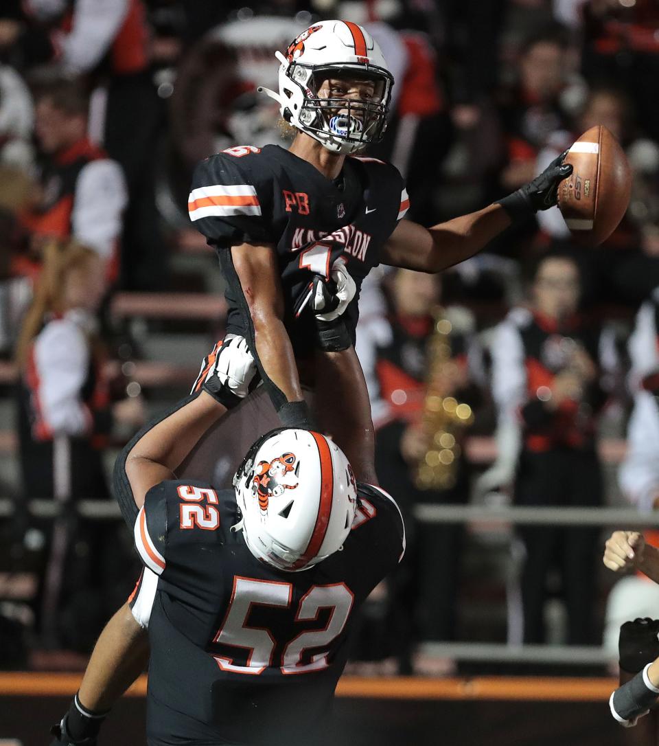 Massillon's Camden Beasley celebrates a second half touchdown over Reynoldsburg with lineman Marcus Moore at Massillon Friday , September 3, 2021.