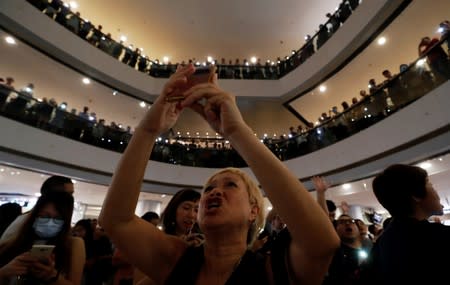 People chant as they hold their mobile phones during a protest at International Finance Center (IFC) in Hong Kong