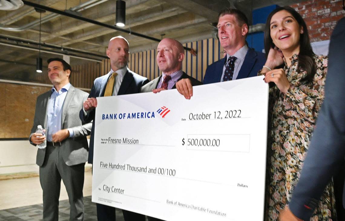 Bank of America Fresno/Visalia CEO Mark Riley, third from left, helps hold a check for $500,000 which was presented to Fresno Mission CEO Mark Dildine, second from right, following a tour of Fresno Mission’s new Heartbeat Hub Wednesday, Oct. 12, 2022 in Fresno.