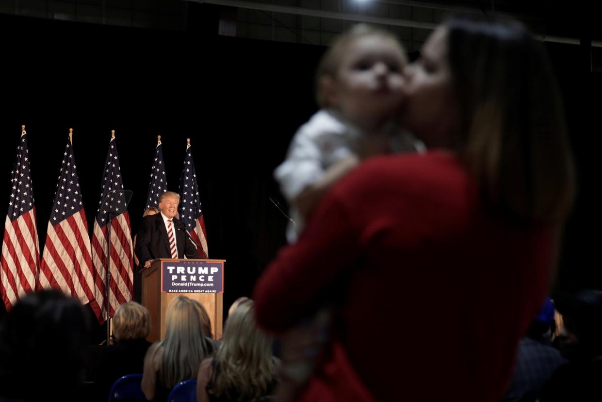 A woman kisses her son while standing in the audience as Republican presidential nominee Donald Trump speaks at a campaign event in Aston, Pa., on Sept. 13. (Photo: Mike Segar/Reuters)