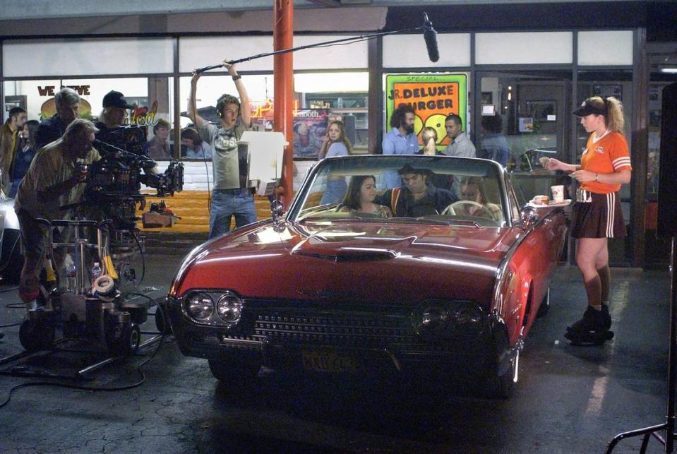 At right, Julie Hale, shift manager for A&W Rootbeer restaurant on G Street, is cast as a waitress on wheels at the same location as she takes the order of Candice Szczepankowski, Jeremy Tristan and Angelina LeBard during filming for the film “American Grace” Thursday night in Modesto.