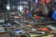 ATTENTION EDITORS - VISUAL COVERAGE OF SCENES OF INJURY OR DEATH The body of a man lies among the debris as another tries to walk towards damaged houses after Typhoon Haiyan hit the municipality of Coron, Palawan province in central Philippines November 9, 2013. Typhoon Haiyan, possibly the strongest storm ever to hit land, has devastated the central Philippine city of Tacloban, killing at least 100 people and destroying most houses in a surge of flood water and high winds, officials said on Saturday. The toll of death and damage is expected to rise sharply as rescue workers and soldiers reach areas cut off by the massive storm, now barrelling out of the Philippines towards Vietnam. REUTERS/Office of the Mayor of Coron, Palawan/Handout via Reuters (PHILIPPINES - Tags: DISASTER ENVIRONMENT) ATTENTION EDITORS - THIS IMAGE WAS PROVIDED BY A THIRD PARTY. FOR EDITORIAL USE ONLY. NOT FOR SALE FOR MARKETING OR ADVERTISING CAMPAIGNS. NO SALES. NO ARCHIVES. THIS PICTURE WAS PROCESSED BY REUTERS TO ENHANCE QUALITY. AN UNPROCESSED VERSION WAS PROVIDED SEPARATELY. TEMPLATE OUT