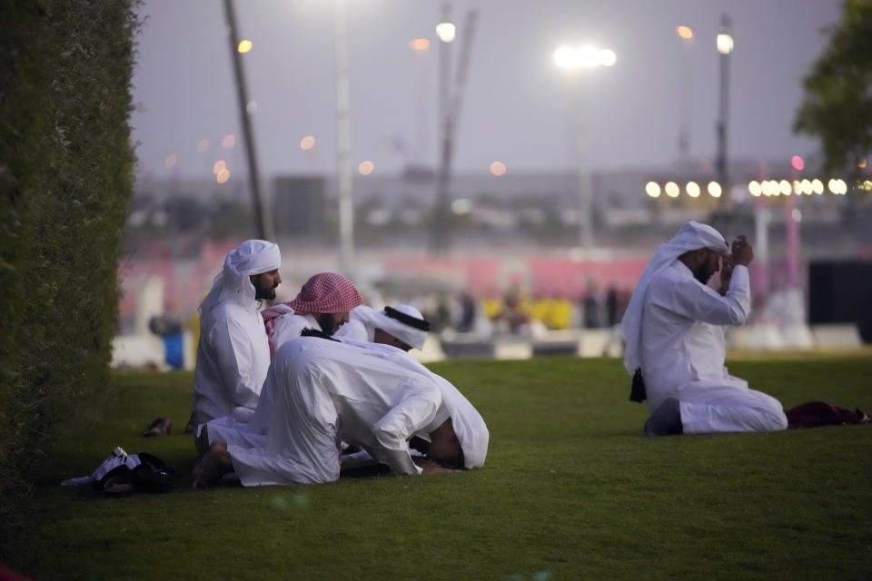 Men pray before the World Cup, group A soccer match between Qatar and Ecuador at the Al Bayt Stadium in Doha, Sunday, Nov. 20, 2022. (AP Photo/)