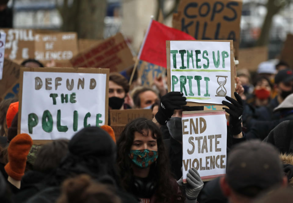 Demonstrators hold up placards as they gather outside New Scotland Yard in London, Sunday, March 14, 2021 during a protest over the abduction and murder of Sarah Everard and the subsequent handling by the police of a vigil honoring the victim. London's Metropolitan Police force was under heavy pressure Sunday to explain its actions during a vigil for Sarah Everard whom one of the force's own officers is accused of murdering. (AP Photo/Frank Augstein)